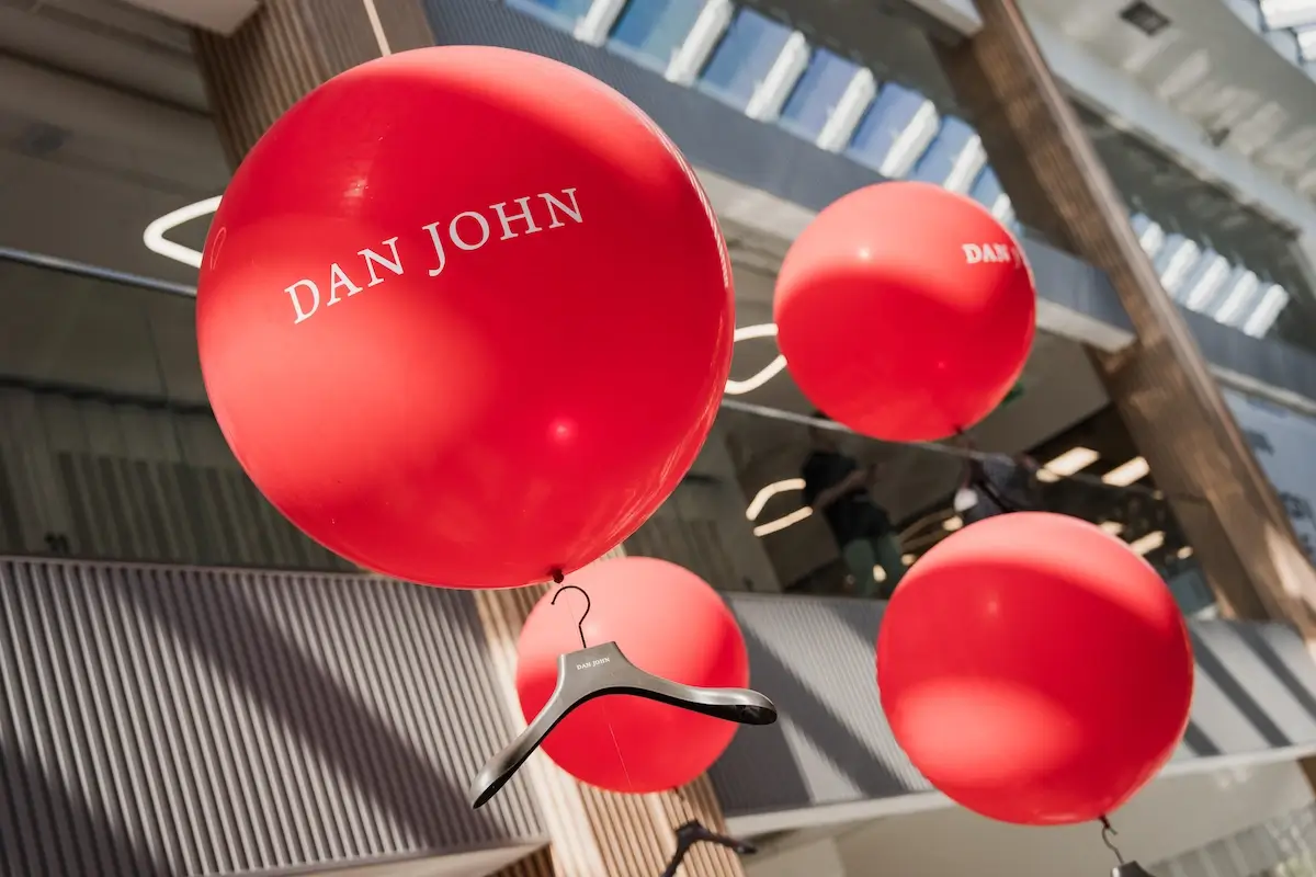 Red balloons with the "Dan John" inscription indoors